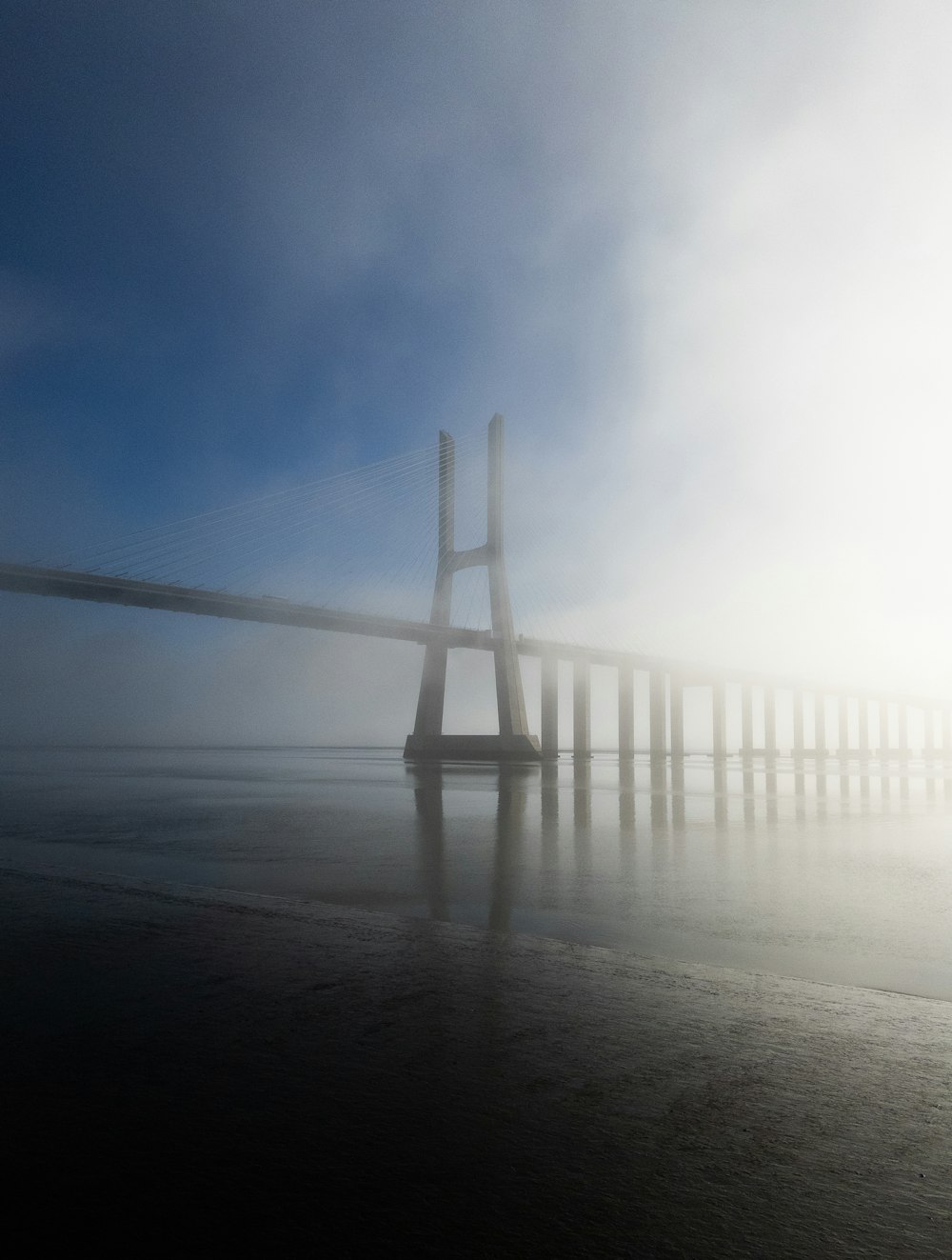 a foggy view of a bridge in the distance