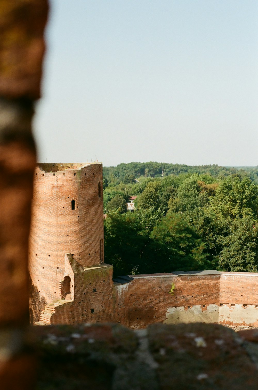 a view of a castle through a hole in a stone wall