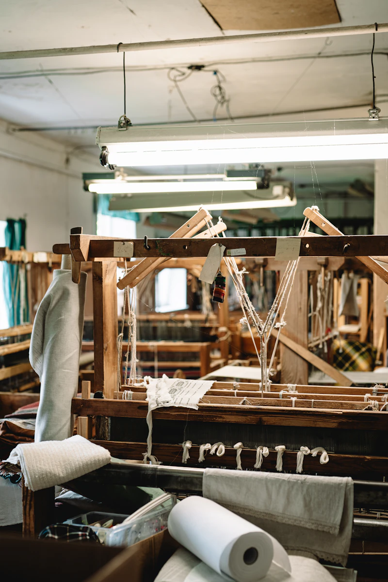 A wooden loom threaded with linen yarn in a weaving mill