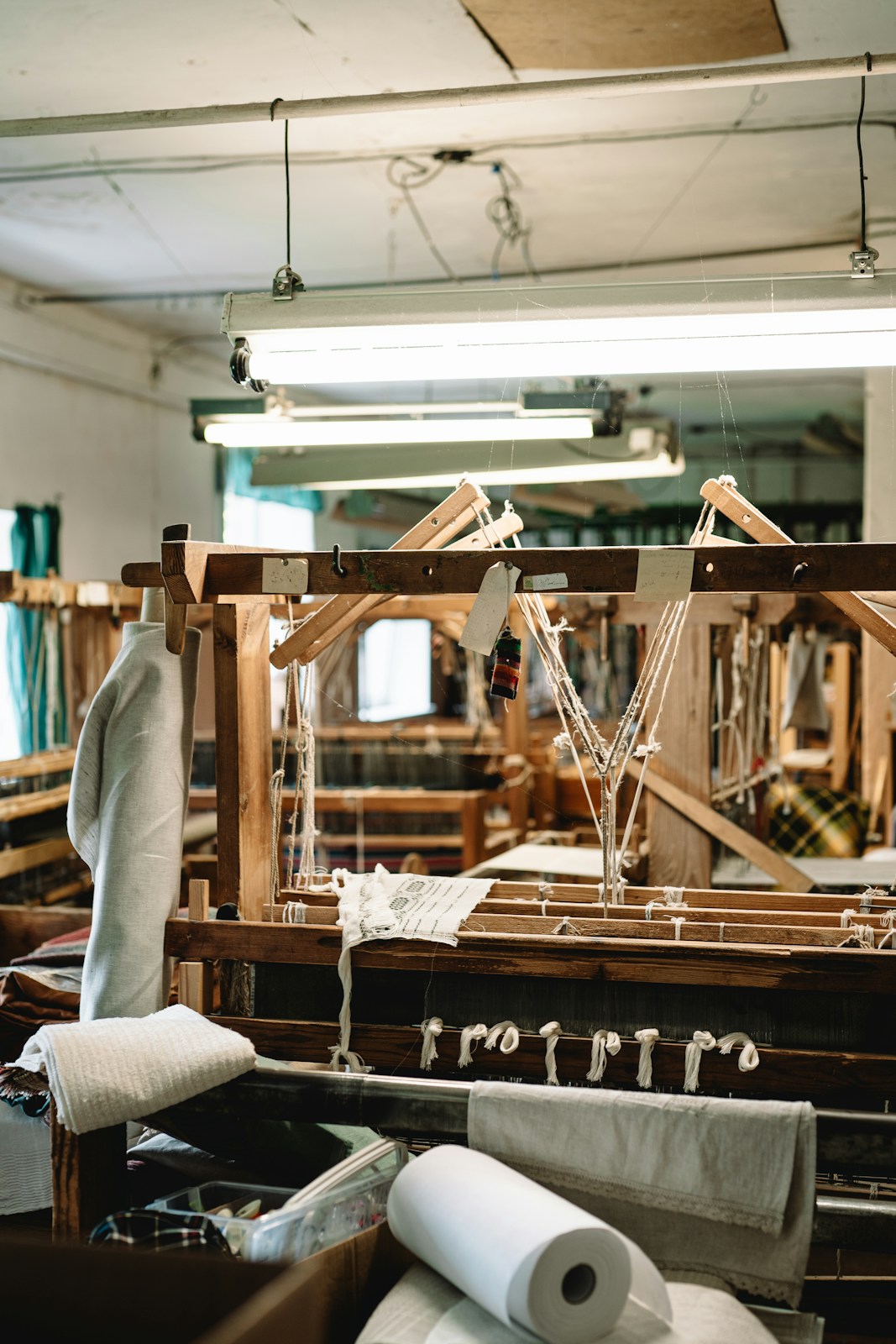Artisan hands guiding a tufting gun across a stretched wool backing
