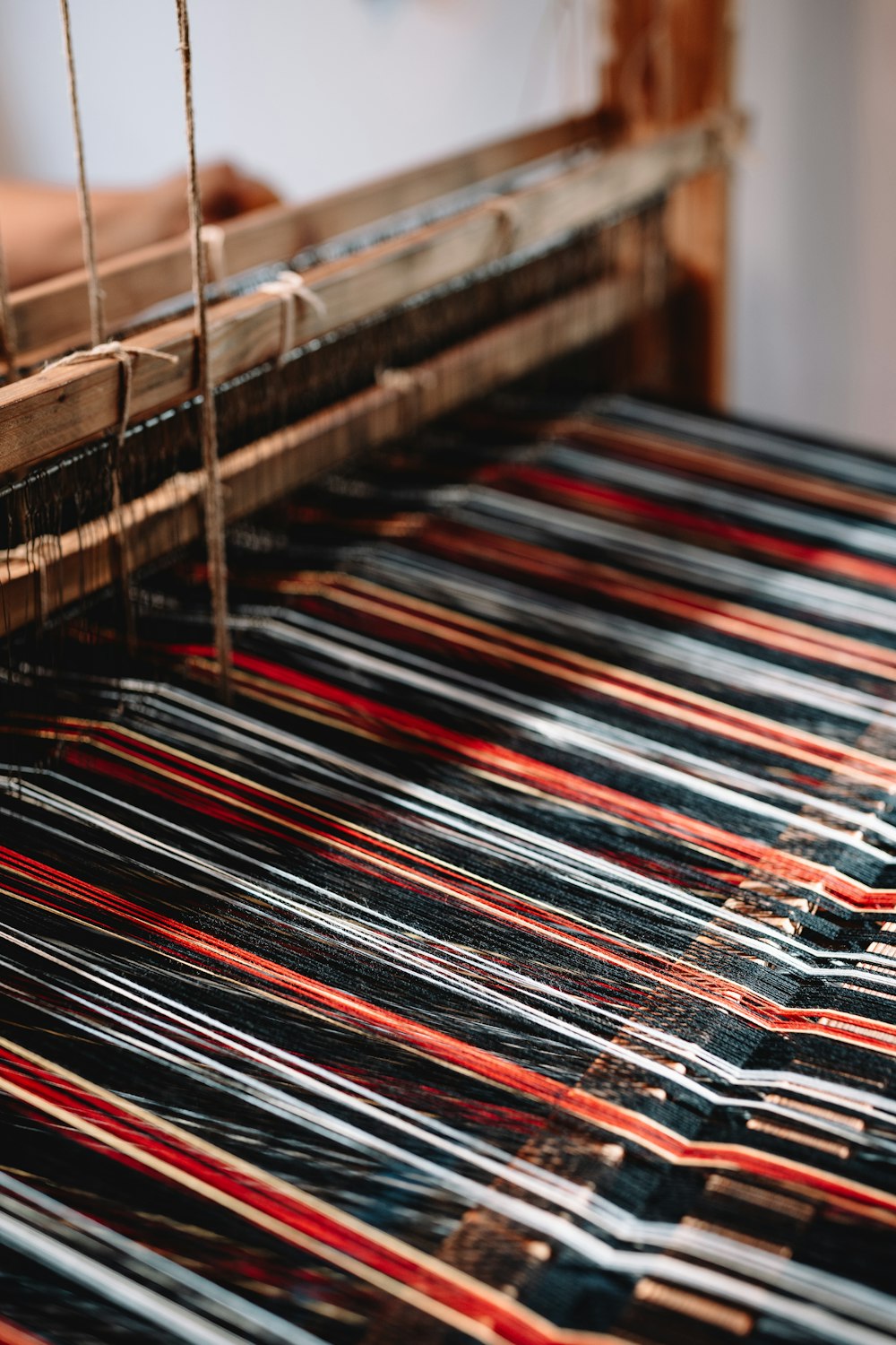 a close up of a weaving machine with red and black lines