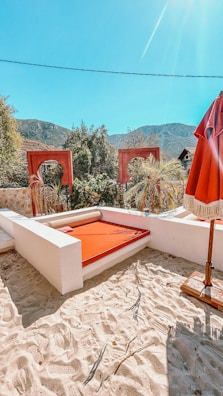 An outdoor daybed nestled among blooming garden flowers on a sunny afternoon.