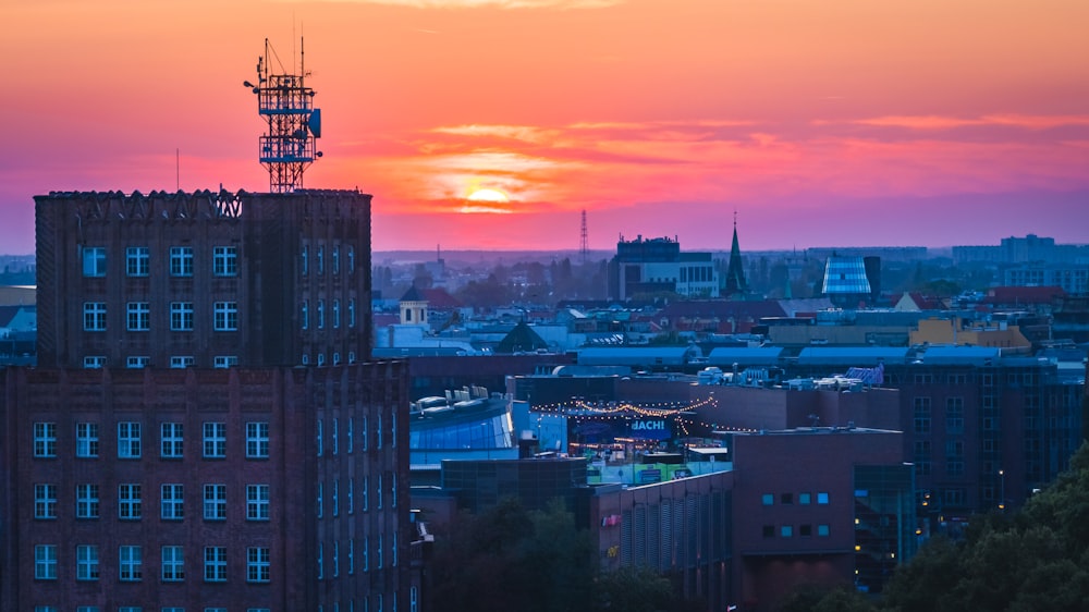 the sun is setting over a city with tall buildings