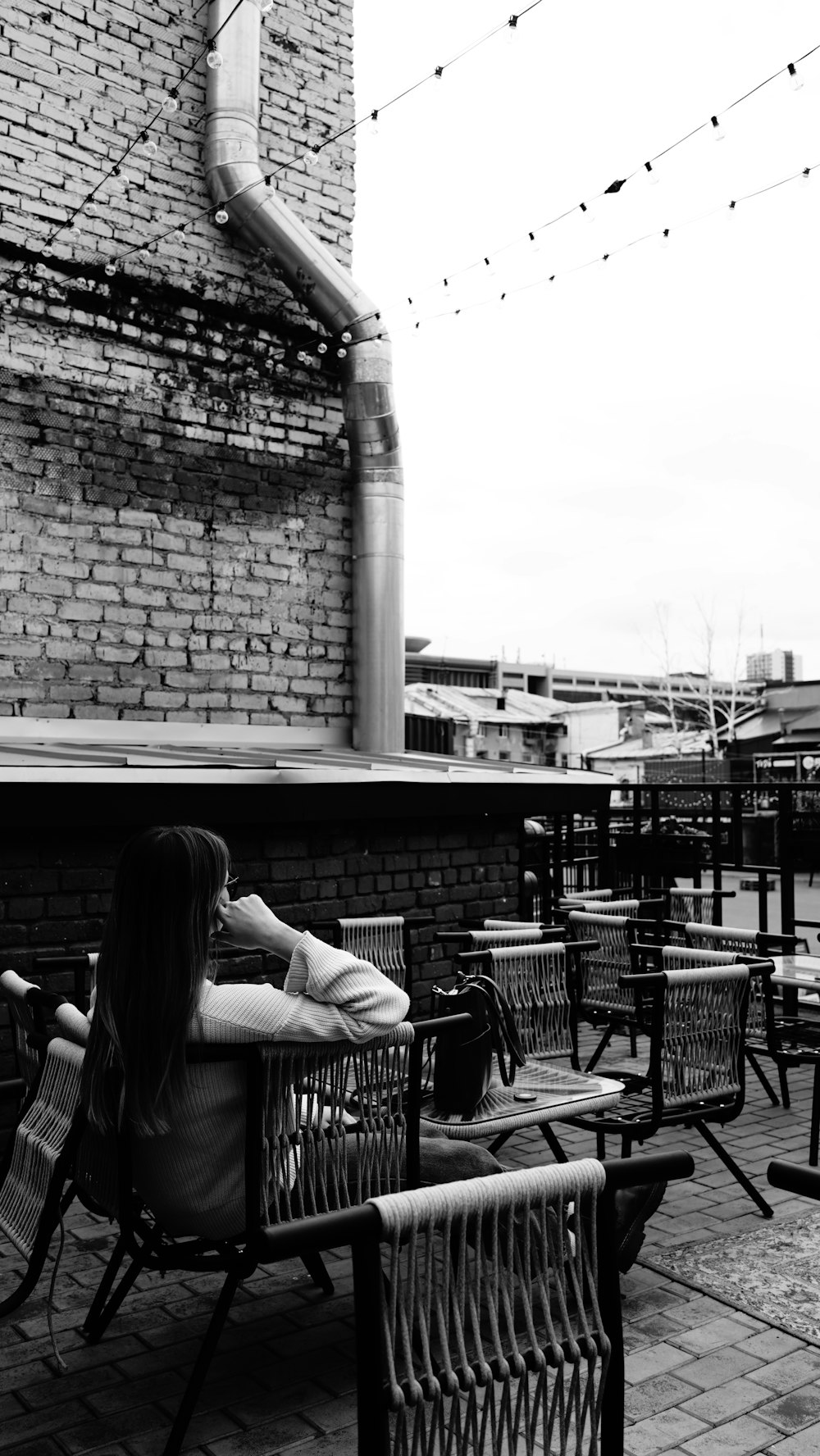 a woman sitting on a bench in front of a brick building