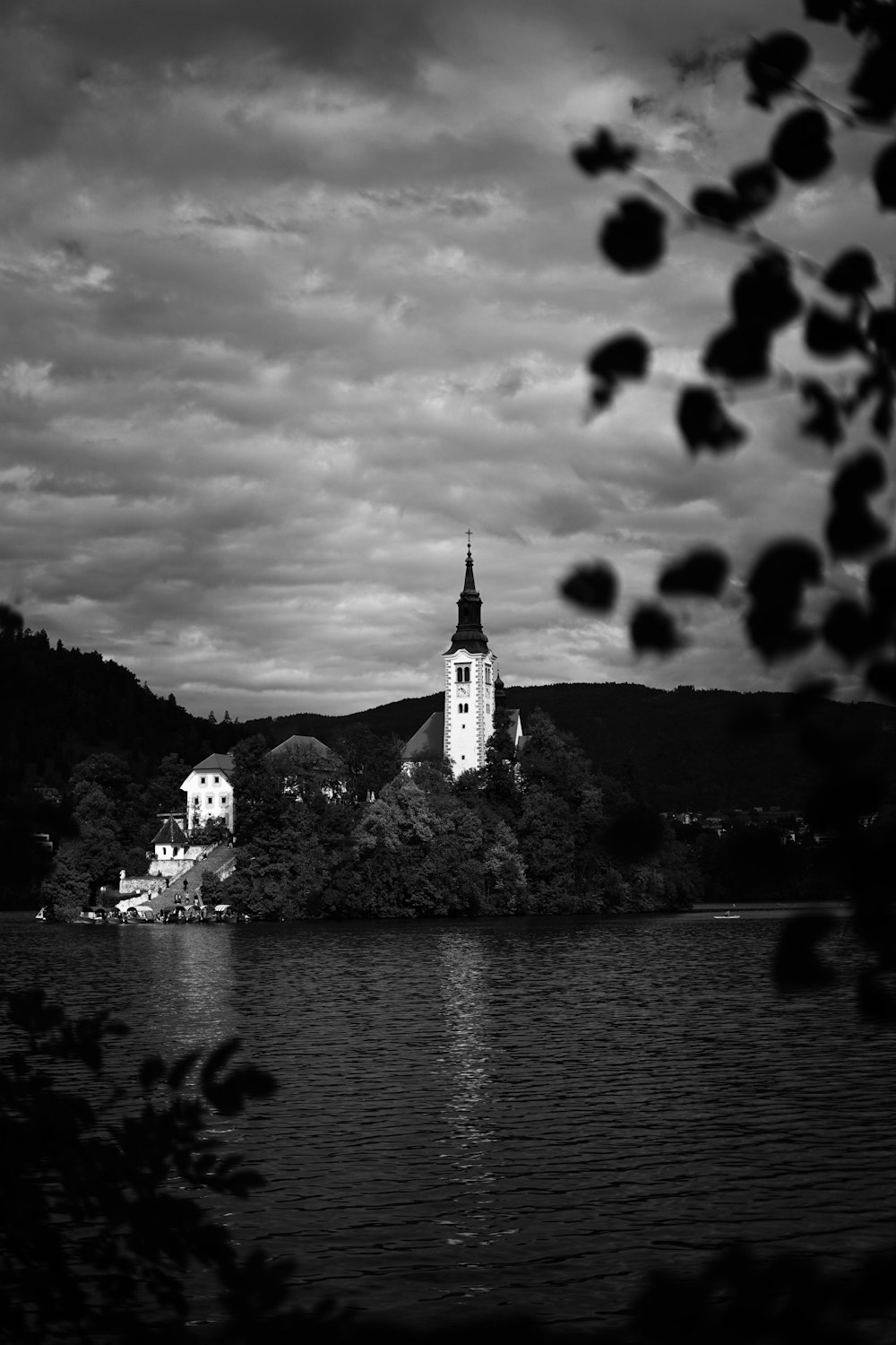 a black and white photo of a church on a lake