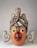 A beautifully handcrafted cedar mask showcasing intricate designs and natural wood grain.