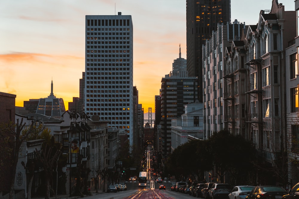 a city street at sunset with tall buildings