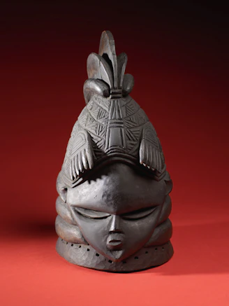 Close-up of a finely carved wooden mask with rich textures and earthy tones.