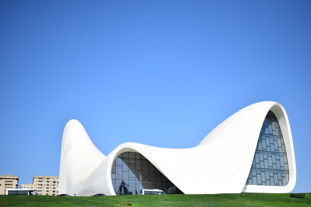 a large white building on top of a lush green field