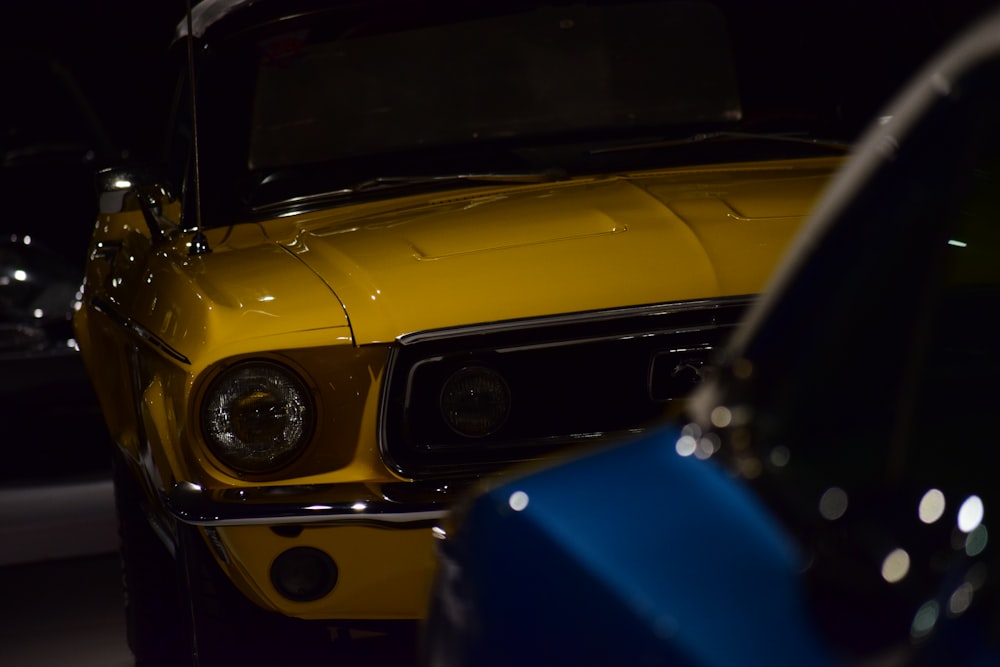 a close up of the front of a yellow mustang