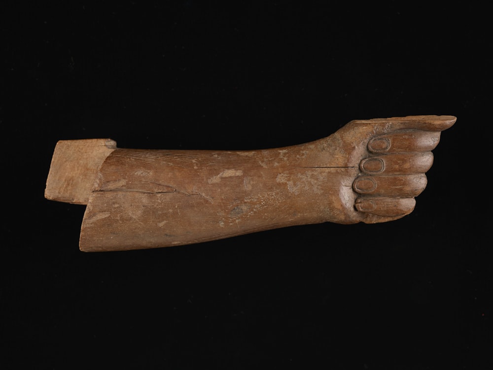 a wooden statue of a hand holding something
