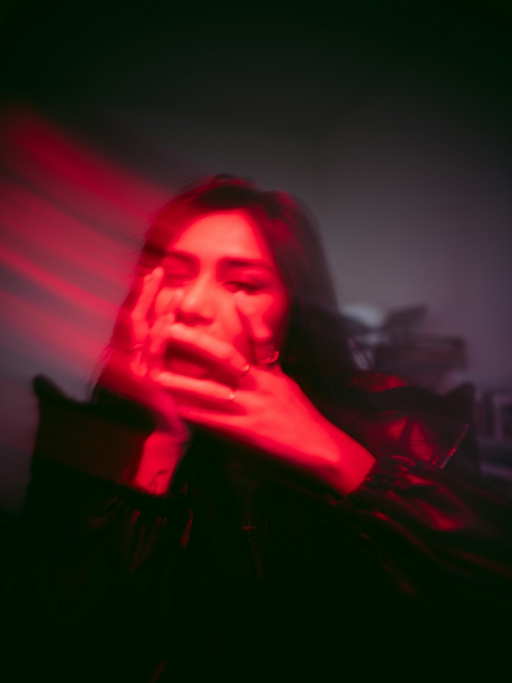 a woman in a dark room with a red light