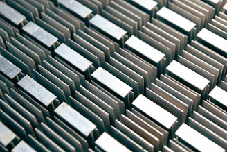 Top view of a metal block showing complex wire EDM patterns with sharp, clean lines.