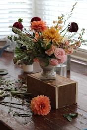 a wooden table topped with a vase filled with flowers
