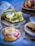 A variety of pastries and bread are arranged on a table. There's a slice of bread with green pesto filling placed on a wooden board, surrounded by other pastries, including one with a pink filling and a crumbly top.
