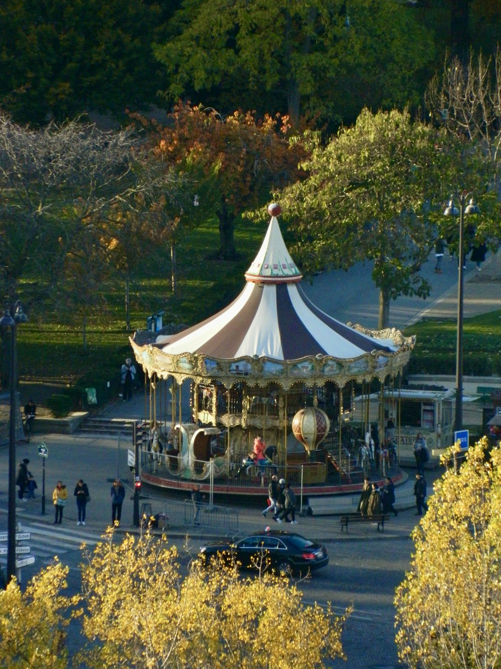 a carousel in the middle of a park surrounded by trees
