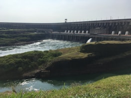 Close-up of flowing water in a hydroelectric dam surrounded by lush vegetation.