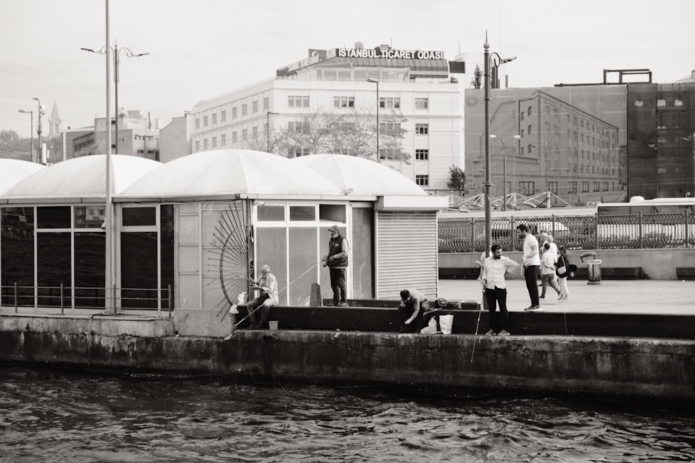 a group of people standing next to a body of water