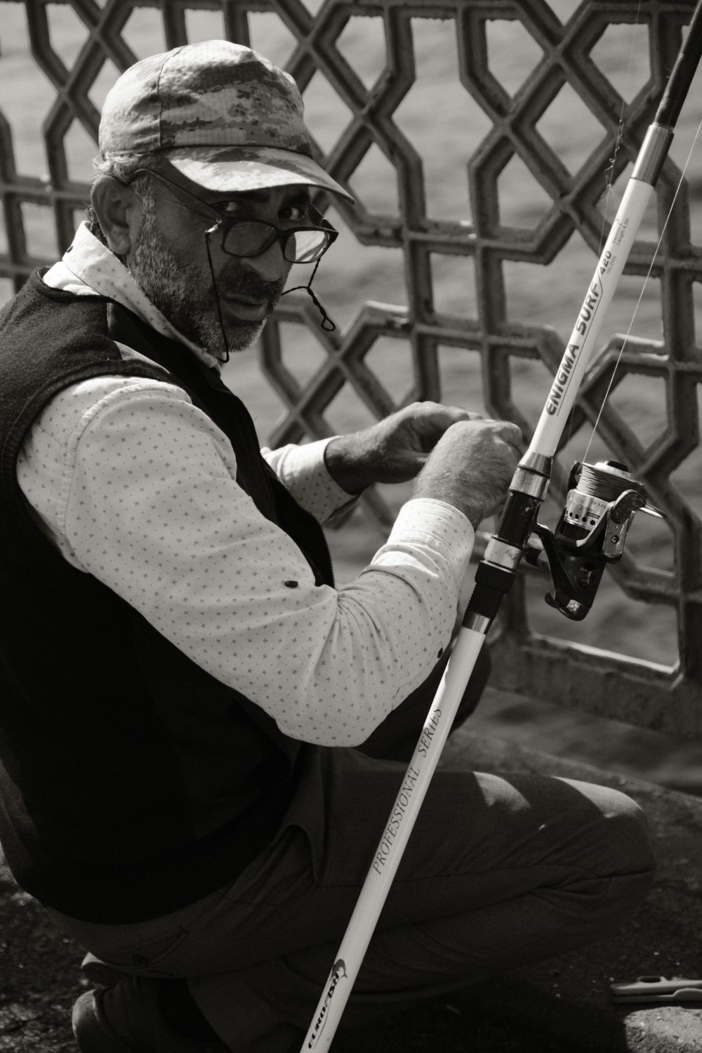 a man sitting on the ground while holding a fishing pole