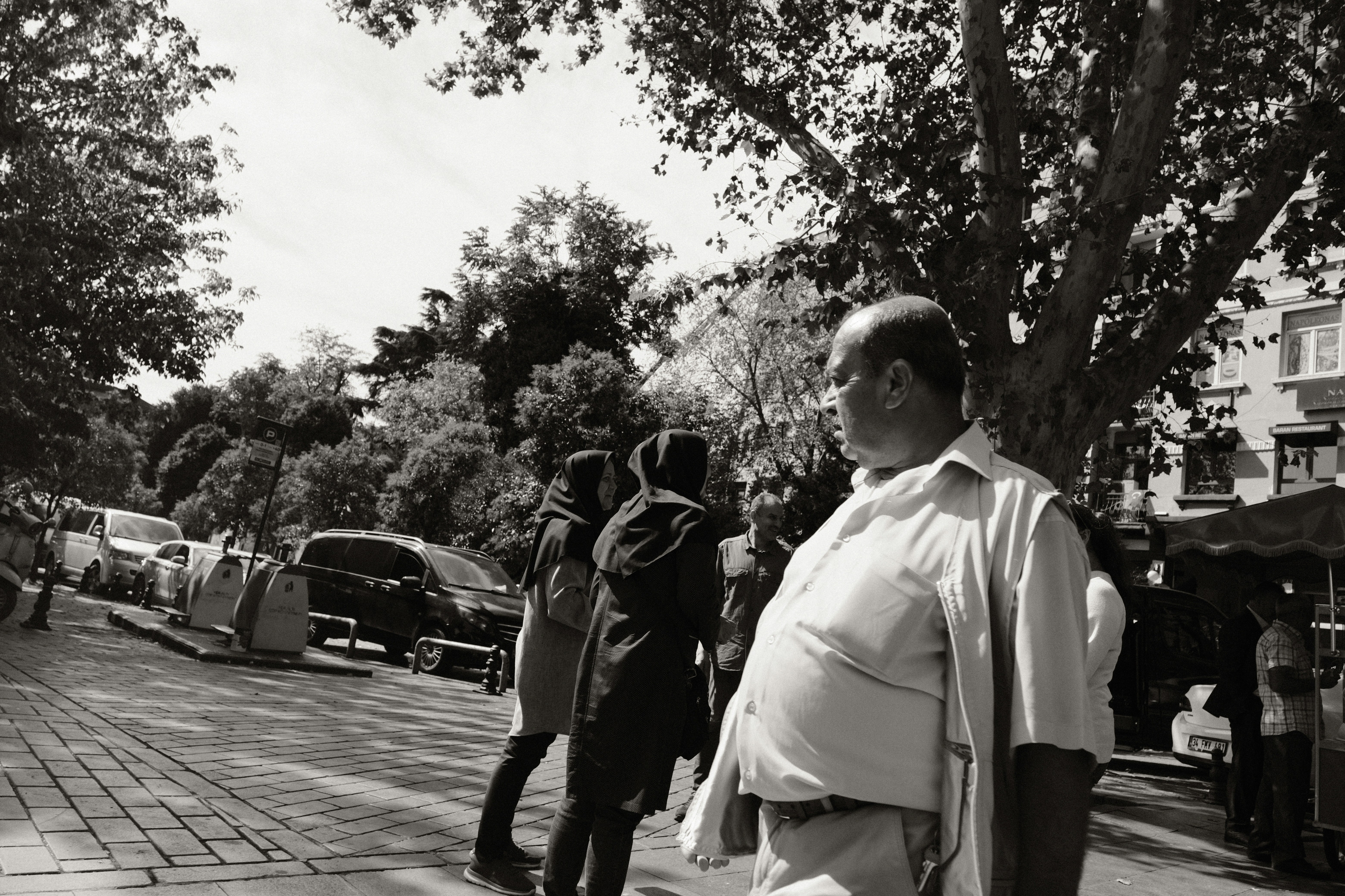 a black and white photo of a man walking down the street
