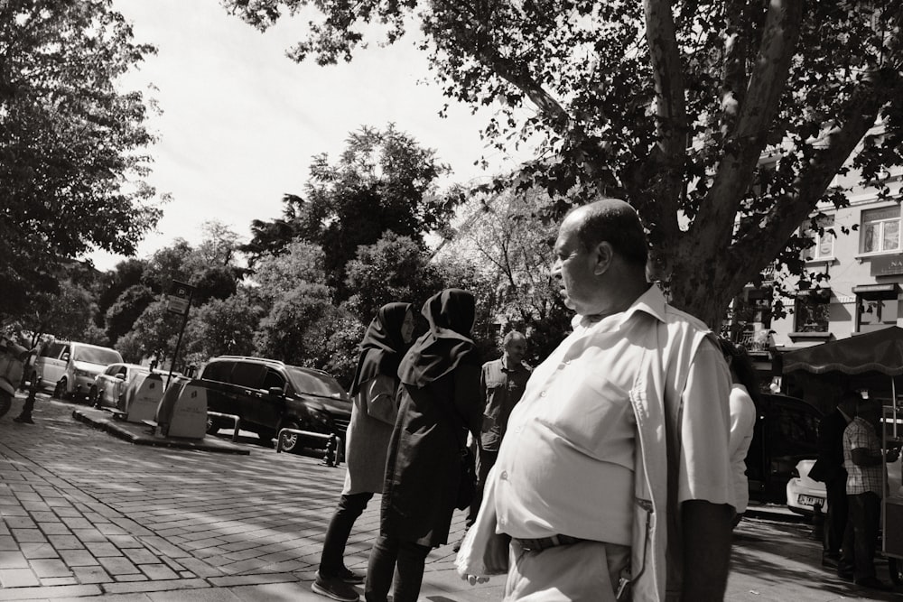 a black and white photo of a man walking down the street