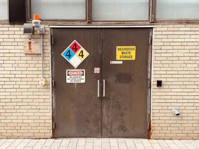 Close-up of biohazard warning signs on a door during cleanup operation.