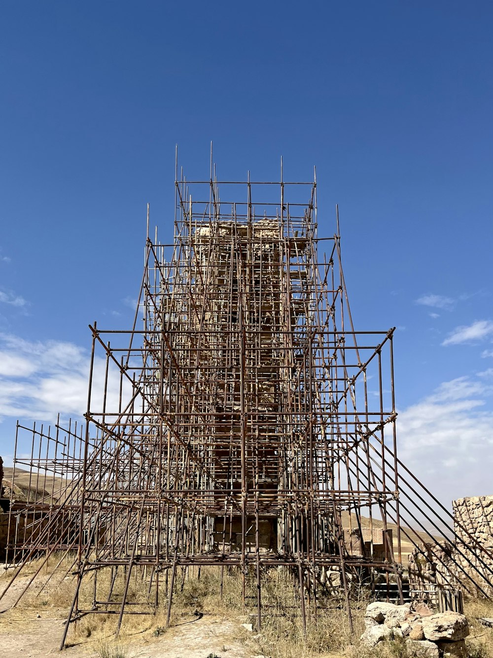 a large structure made of wooden sticks in the desert