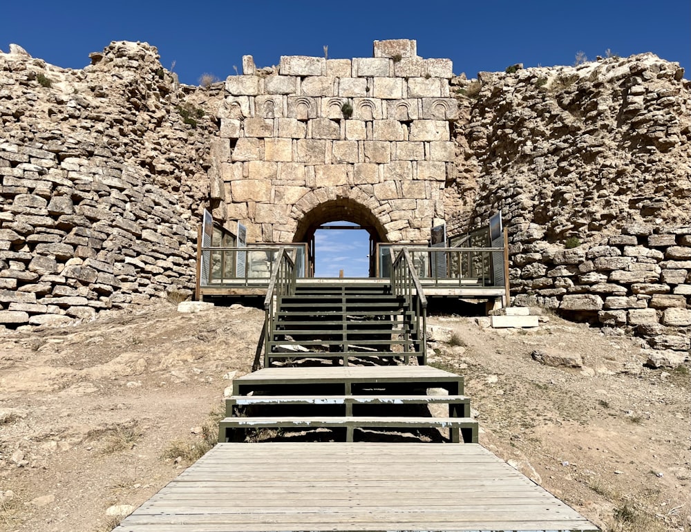 a set of stairs leading up to a stone wall