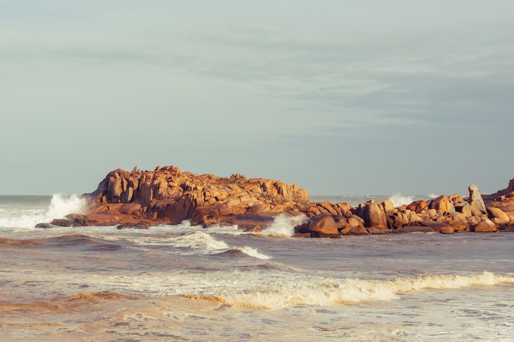 a rocky shore with waves crashing against the rocks