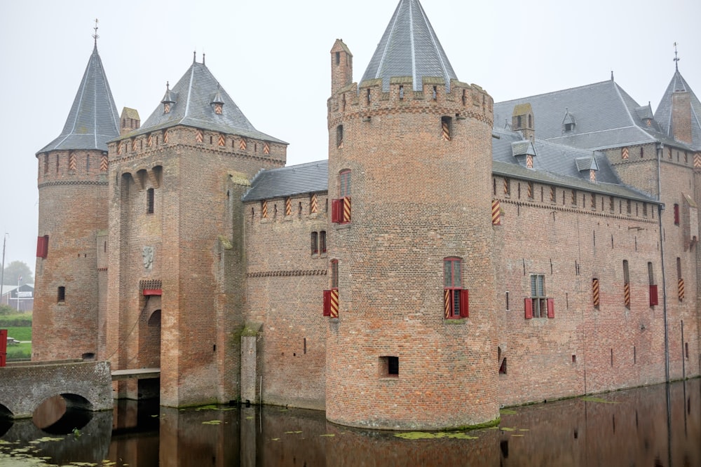 a large castle with two towers next to a body of water