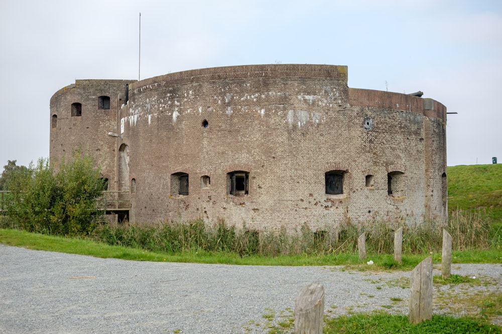 Un gran edificio redondo sentado en la cima de un exuberante campo verde