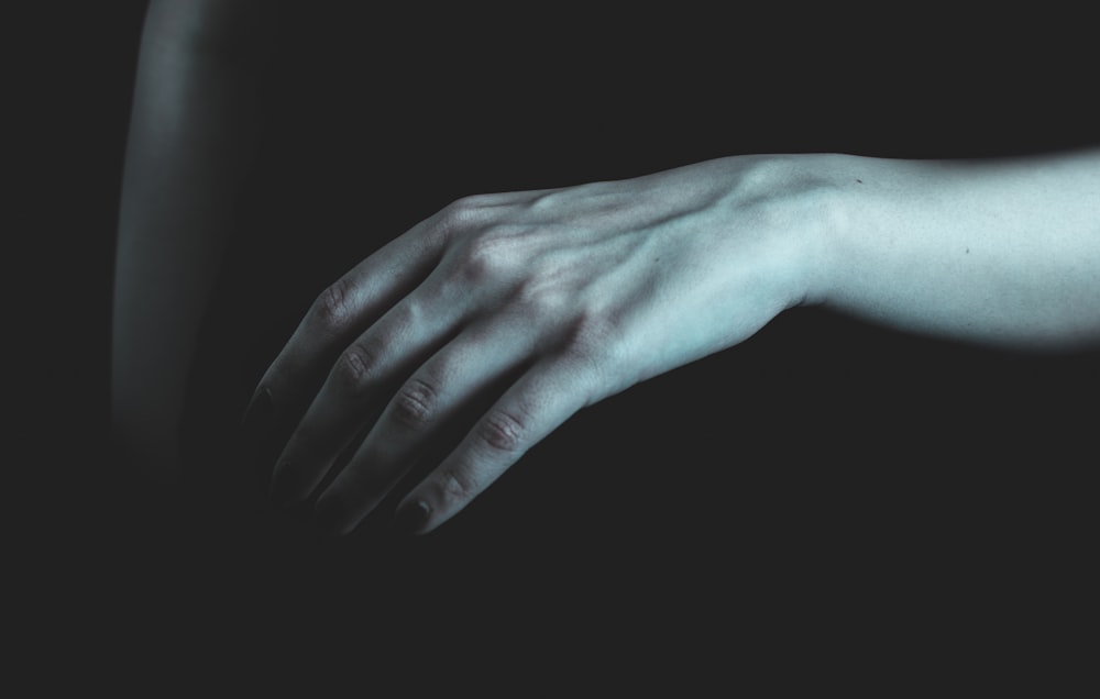 a person's hand with a black background