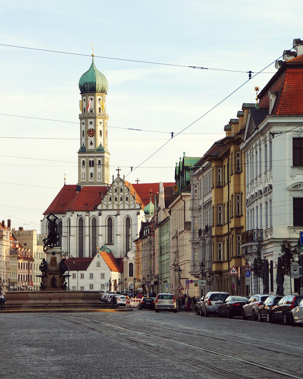 Eine Stadtstraße, die von hohen Gebäuden und einem Glockenturm gesäumt ist