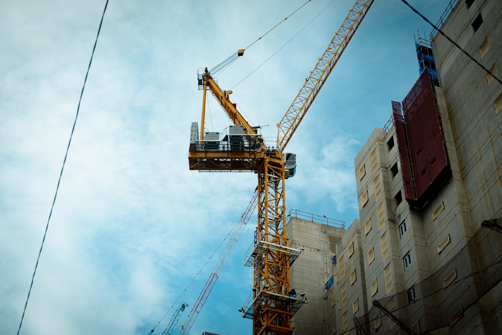 a crane is standing next to a building under construction