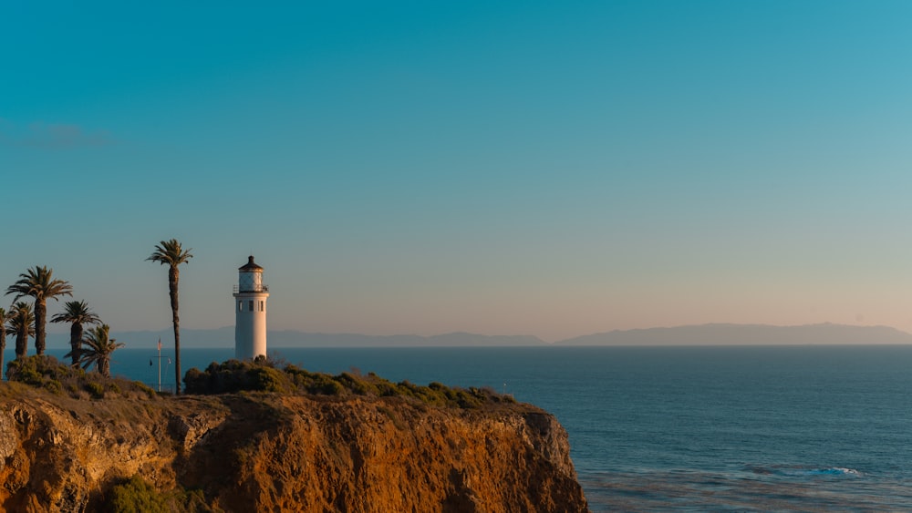 a light house sitting on top of a cliff next to the ocean