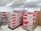 An enthusiastic woman inspecting neatly stacked corrugated boxes in a bright packaging room.