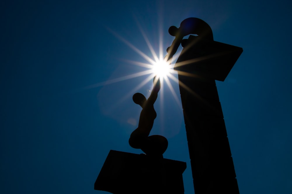 the sun shines brightly behind a statue