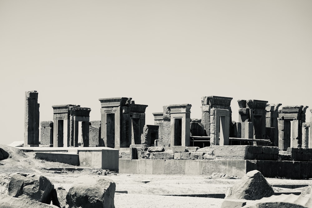 a black and white photo of ruins in the desert