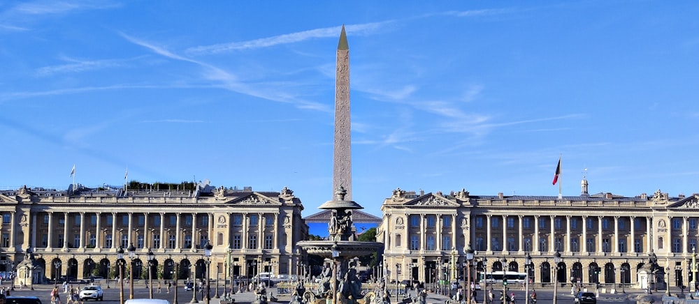 un grande edificio con un alto obelisco di fronte ad esso