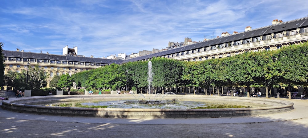 a fountain surrounded by trees in a courtyard