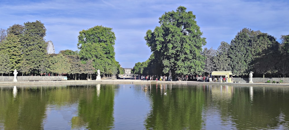 a lake surrounded by trees and a park bench