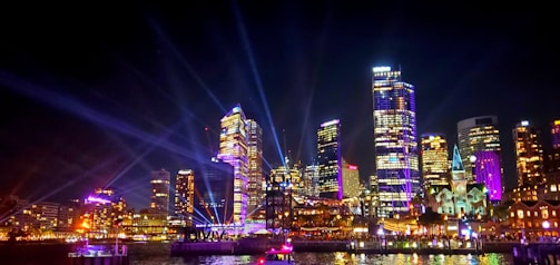 Evening city skyline with concert lights shining bright.