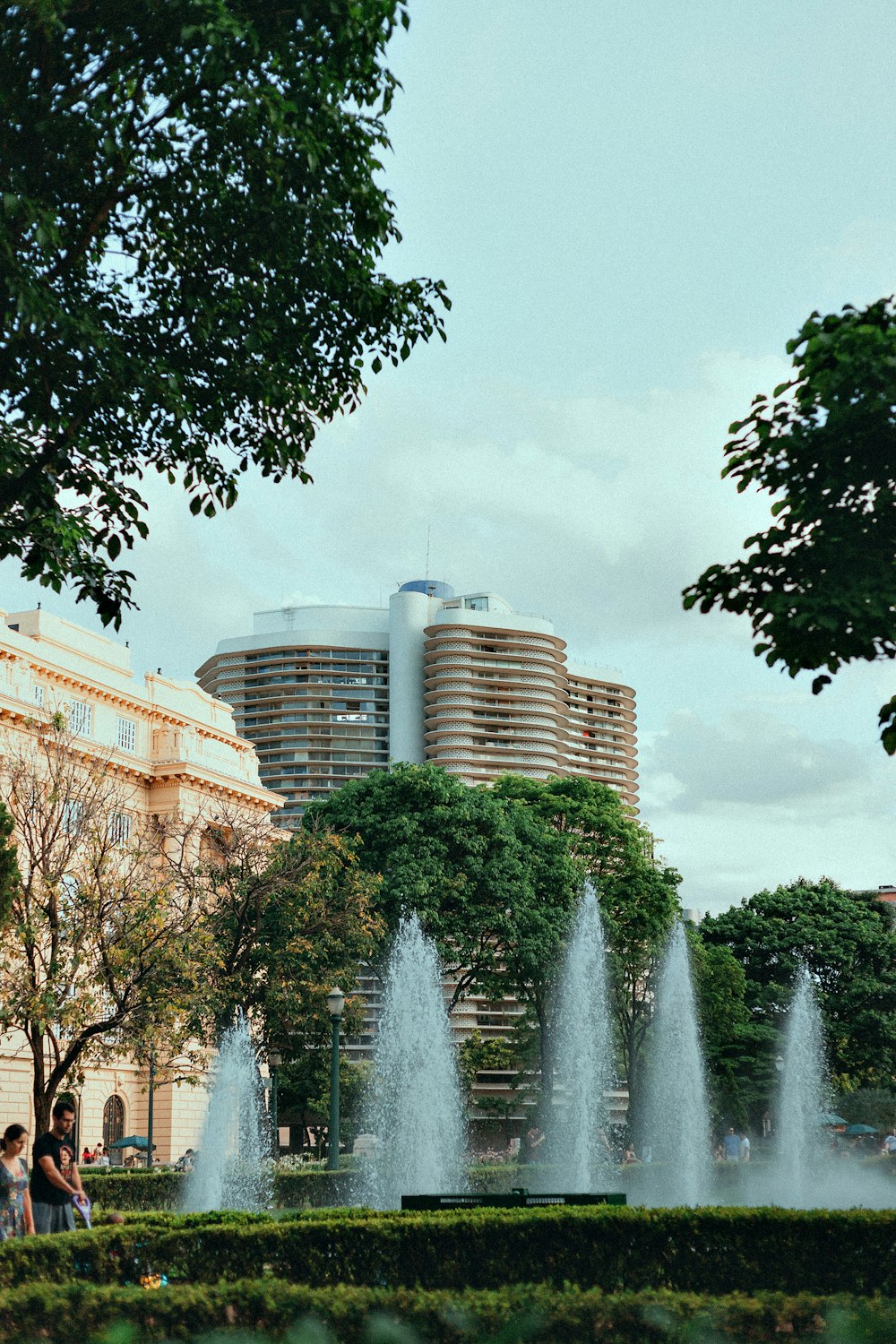 a group of people standing in front of a fountain