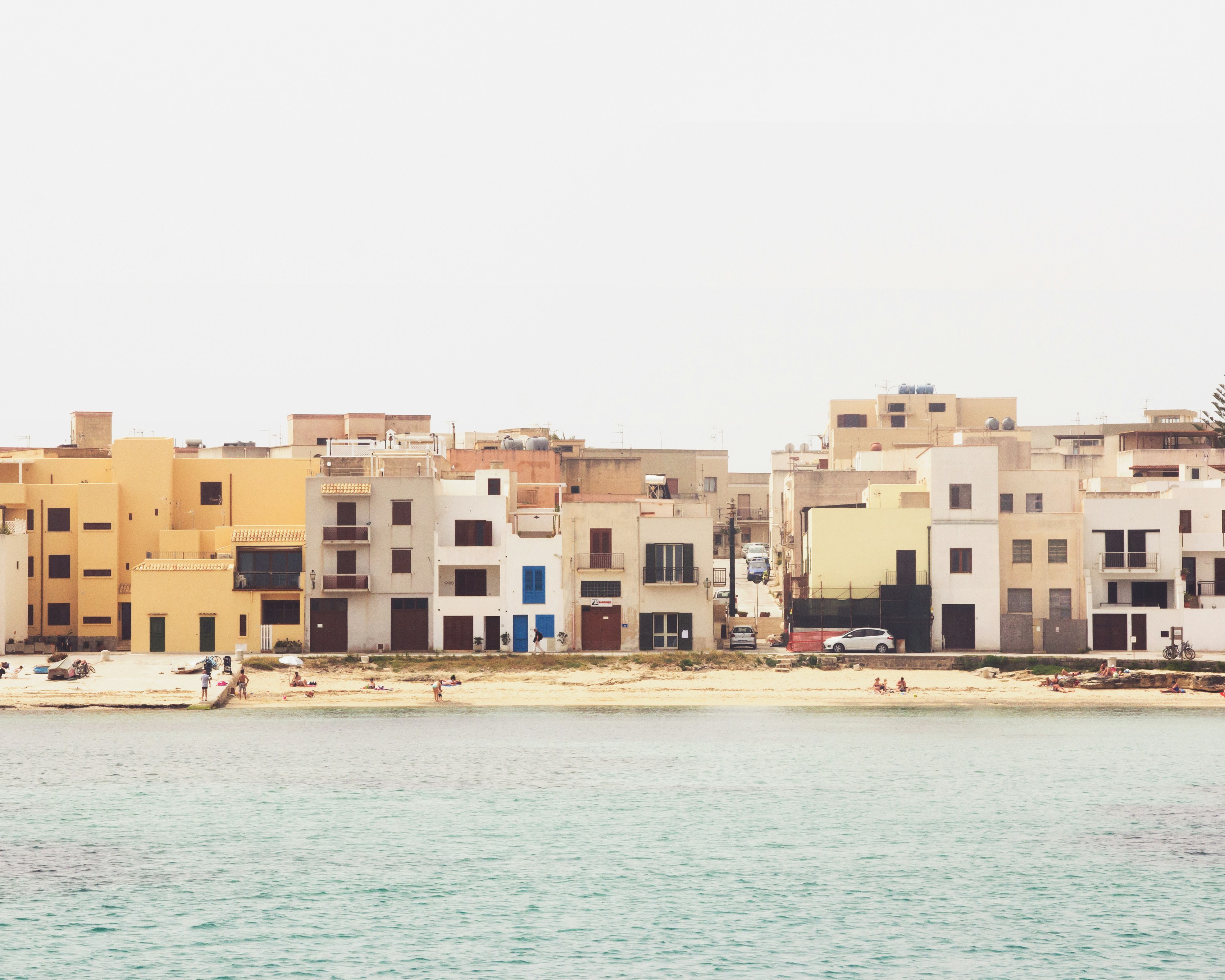 a body of water with a bunch of buildings in the background, Jumbled Houses in Sicily, Italy