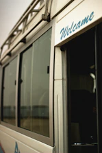 A professional driver greeting passengers as they board a clean corporate shuttle bus.