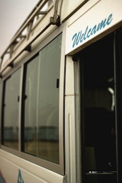 A friendly driver opening the door of a sleek shuttle van at the airport terminal.