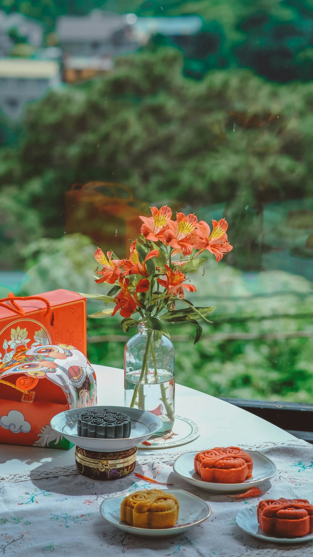 a table topped with plates of food and a vase of flowers