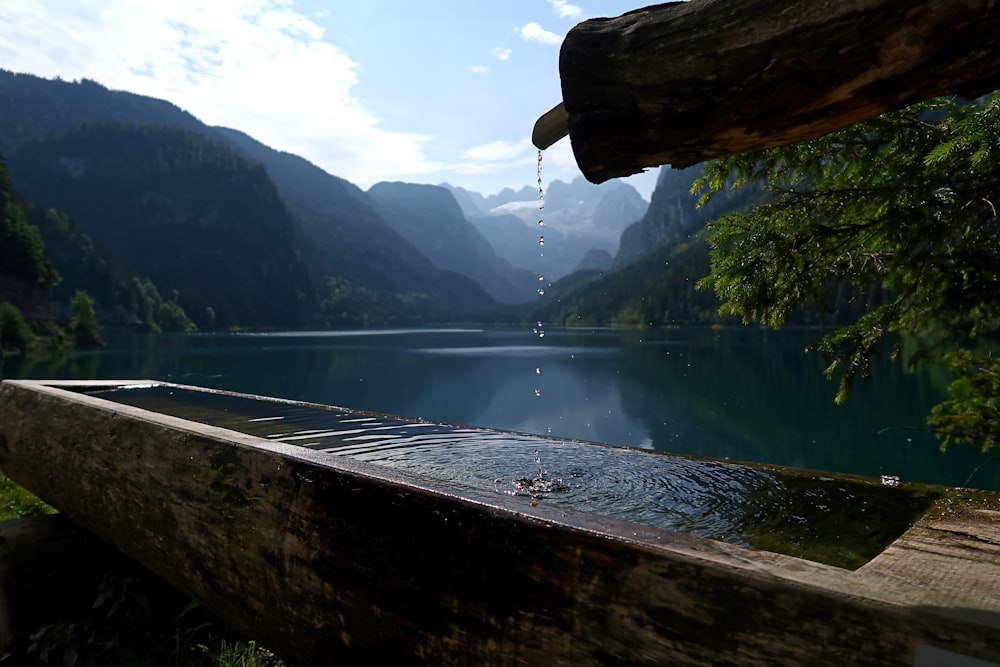 a wooden bench sitting on the side of a lake
