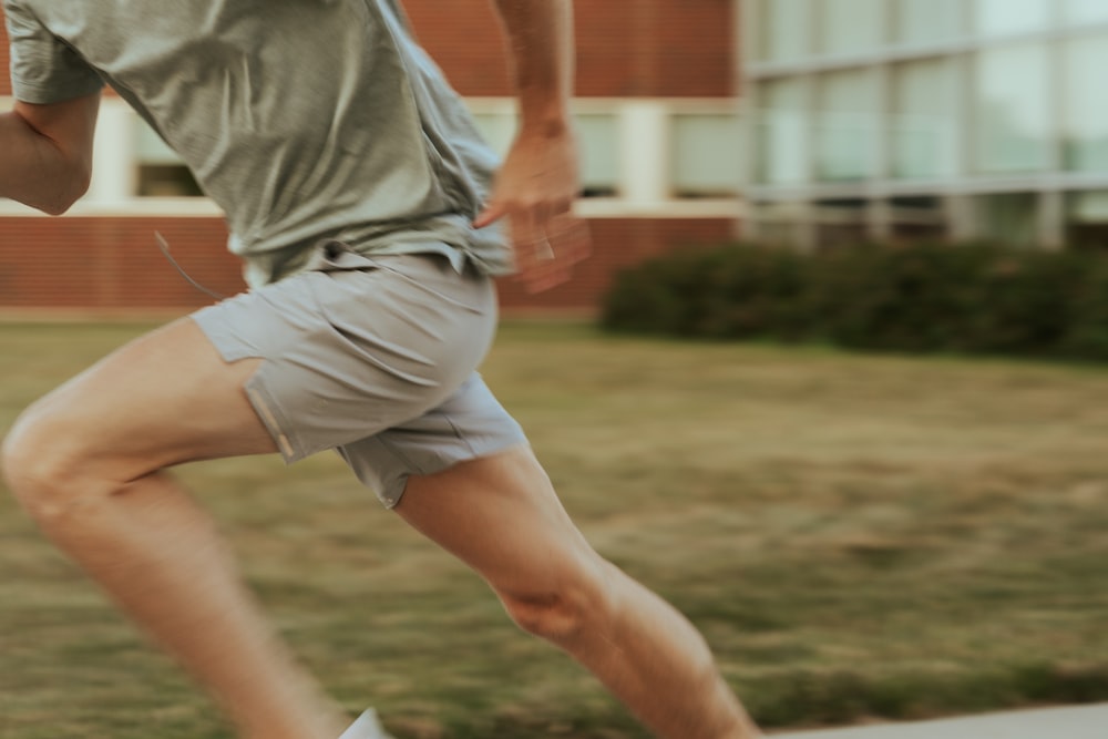 a man in shorts and a t - shirt is playing with a frisbee