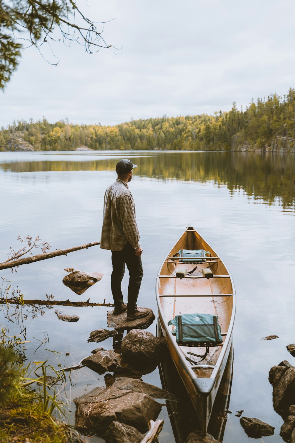 a man standing next to a boat on a lake